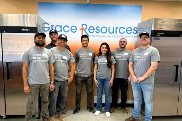 produce-30-gros webp A diverse group of six individuals wearing matching t-shirts that read "Building Better Communities" stands in front of a branded backdrop.